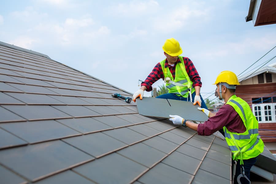 Roofing crew installing a shingle roof